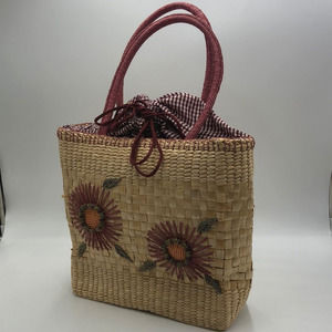 Straw shoulder bag with flower details. Checkered cinch top closure.